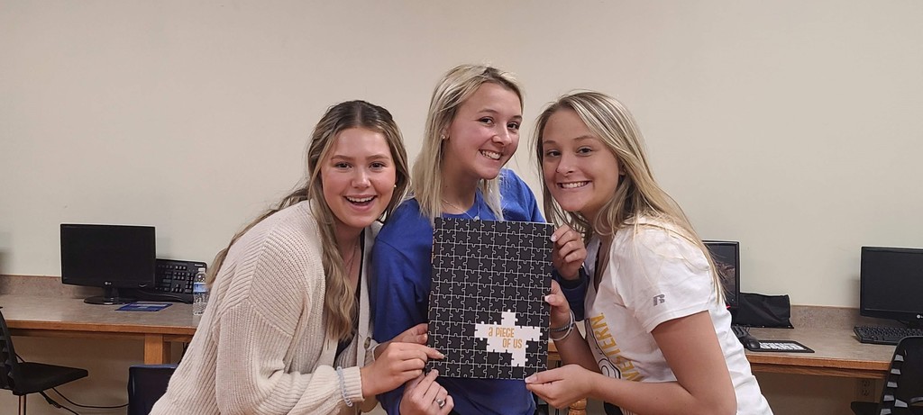 Carissa Martin, Natalyn Killoren, and Carli Browning display the 21-22 DHS Yearbook.